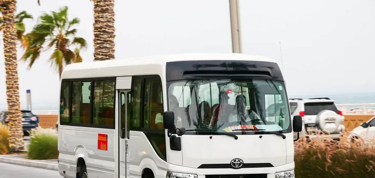 Toyota Coaster carrying staff on a Dubai road, used by staff transport companies for daily employee runs