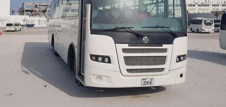 Ashok Leyland bus with a Dubai number plate parked at the Alsinan Transport yard